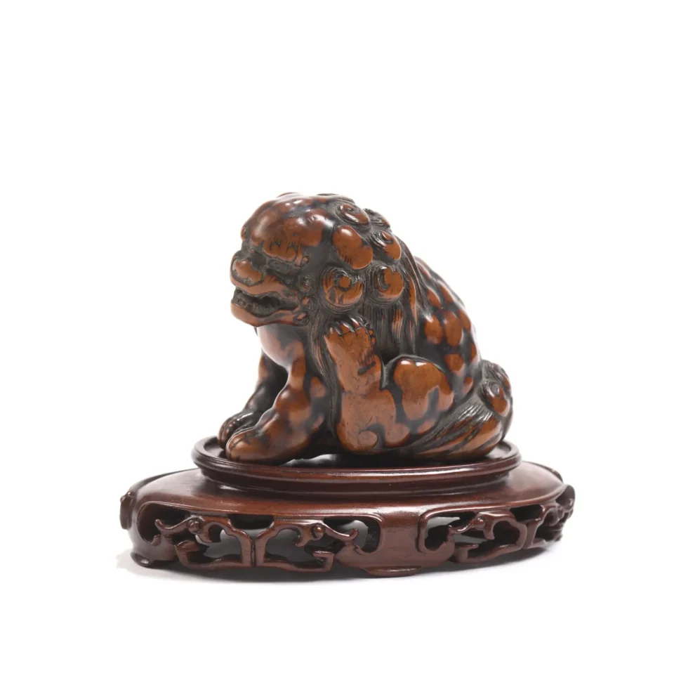 Netsuke en buis de belle patine, représentant un shishi assis se grattant l’oreille gauche avec sa patte - JAPON - XVIII-XIXe siècle