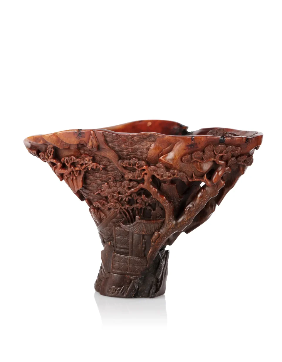 Large rhinoceros* horn libation cup, finely carved with a mountain range planted with pine trees, - CHINA - 17th-18th century